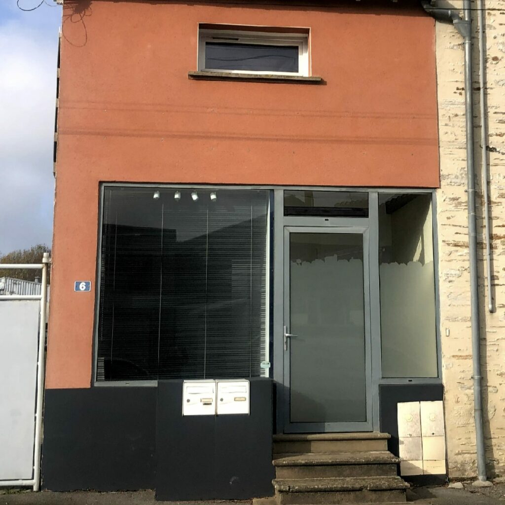 Façade du cabinet de Blain : devanture orange avec porte vitrée et le numéro 6
