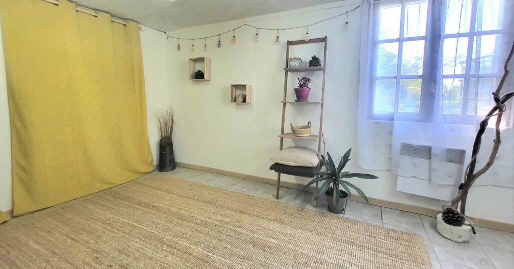 Cabinet de Guenrouët : pièce lumineuse avec rideau jaune, étagère en bois et tapis de jute
